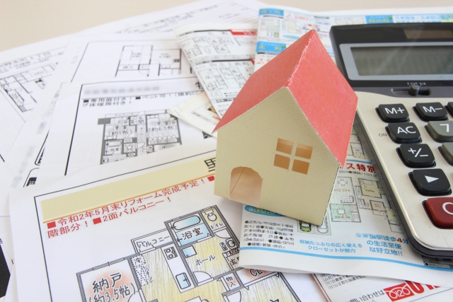 家の模型と不動産のチラシ